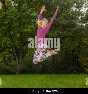 Junge Frau springt in der Luft,Wiese,am kappelberg,baden-württemberg,deutschland Stockfoto