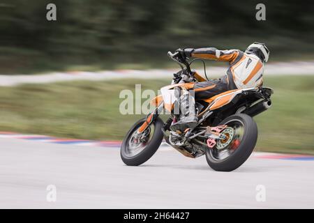 Motorrad-Praxis lehnt sich in eine schnelle Ecke auf der Strecke Stockfoto