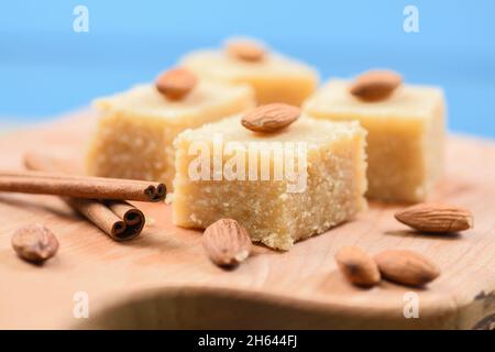 Traditionelles indisches Dessert, Halva aus Grieß und Milch mit Zimt und Mandeln auf blauem Hintergrund aus nächster Nähe Stockfoto