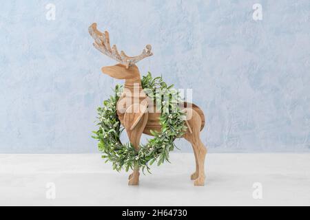 Holzrentiere mit Weihnachtskranz auf farbigem Hintergrund Stockfoto