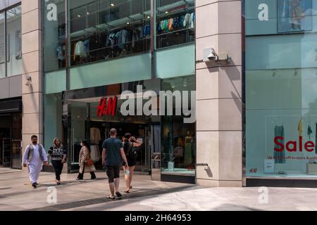 High Wycombe, England - 21. Juli 2021: Leute, die ein H&M-Geschäft betreten und verlassen. Die Kette ist im Besitz eines schwedischen Meuterungs Stockfoto