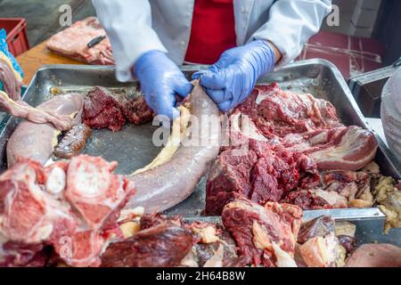 Qazy, Pferdefleischwurst wird in qarta (Pferdedarm) gestellt. Von den Händen in Handschuhen verpackt, um auf dem Fleischmarkt Altyn Orda, Almaty, Kasachstan verkauft zu werden Stockfoto
