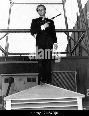 DAVID McCallum als Illya Kuryakin 1964 mit Uncle Special Gun (Pistole-Gewehr-Maschinengewehr) Werbepose für DEN MANN AUS U.N.C.L.E. US TV Series 1964 - 1968) Schöpfer Sam Rolfe Arena Productions / MGM Television Stockfoto