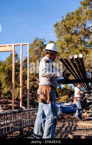Bauarbeiter, die Grade-Balkenkäfige für ein neues Fundament montieren Stockfoto