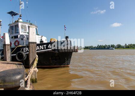 Dordrecht, Niederlande-Juli 2021; Tiefwinkelansicht eines Schleppers, der an einem Kai festgemacht ist, mit im Hintergrund die drei Flüsse, die auf Oude Maas, De zeigen Stockfoto