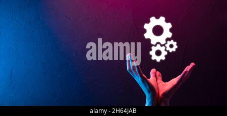 Geschäftsmann im Anzug hält Metallgetriebe und Zahnräder Mechanismus der Interaktion Teamarbeit Konzept, Hand halten Gruppe von virtuellen Zahnräder Rad. Stockfoto