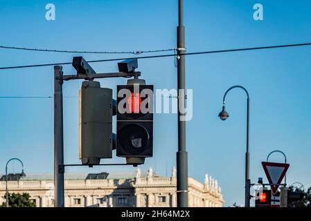 Rote Ampelkreuzung verbietet Fußgängern das Überqueren der Straße. Zwei rote kleine Männer umarmen sich Stockfoto