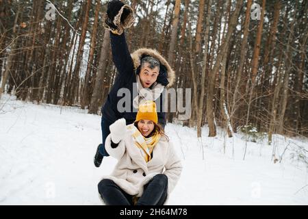 Ein Paar in einem Winterwald haben Spaß auf einem Tag frei Stockfoto