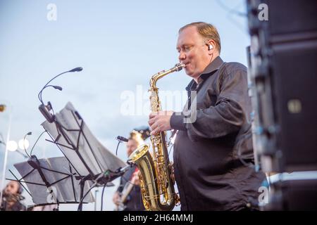 Saxophonist spielt im Orchester unter blauem Himmel Stockfoto