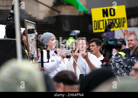 Melbourne, Australien. 13. November 2021. Eine Frau wird während eines Protestes gegen die Regierung von Andrew vor der Treppe des State Parliament in Melbourne mit der Menge gesprochen. Tausende von Demonstranten mussten den Regen ertragen, um gegen die Impfstoffmandate sowie gegen das drakonische Pandemie-Gesetz der Regierung Andrews zu kämpfen. Kredit: Dave Hewison/Speed Media/Alamy Live Nachrichten Stockfoto