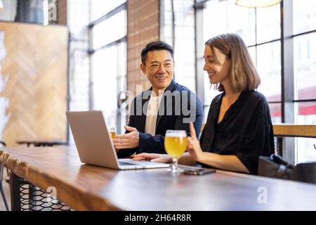 Freunde unterhalten sich und trinken Bier in der Bar Stockfoto