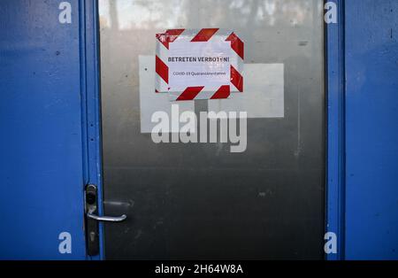 28. Oktober 2021, Berlin: An einer Tür zur Quarantänestation für Obdachlose hängt ein Schild mit der Aufschrift: "No Trespassing! COVID-19 Quarantäne-Station“. Foto: Britta Pedersen/dpa-Zentralbild/dpa Stockfoto