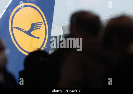 08. November 2021, Hessen, Frankfurt/Main: Hinter den wartenden Passagieren am Frankfurter Flughafen ist das Lufthansa-Logo zu sehen. Foto: Sebastian Gollnow/dpa Stockfoto