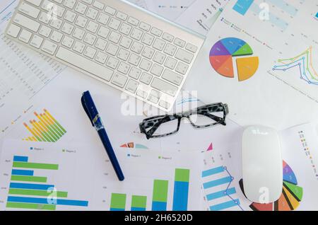 Laptop, Unterlagen mit Zahlen und Grafiken. Ansicht von oben Stockfoto