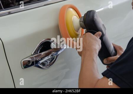 Mann bei der Arbeit Zum polieren, beschichten Autos. Stockfoto