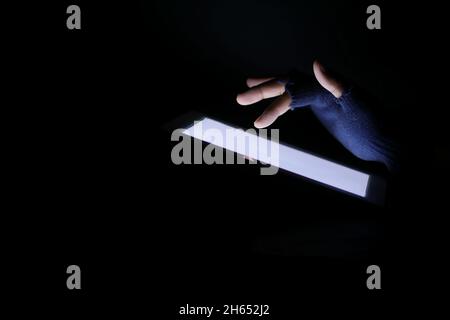 Nahaufnahme von Hacker-Hand stehlen Daten von digitalen Tablet Stockfoto