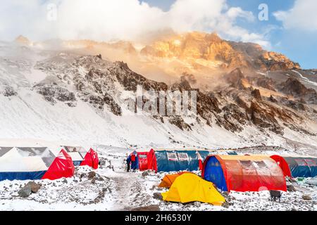 Bergzelte im Aconcagua Basislager 'Plaza de Mulas' nach Schneesturm bei Sonnenuntergang, Mendoza, Argentinien Stockfoto