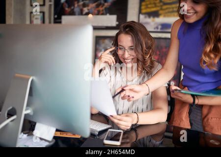 Junge glückliche Kollegen arbeiten im Büro zusammen Stockfoto