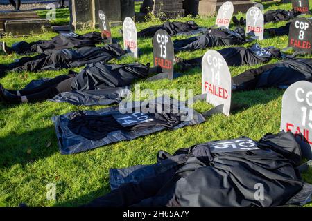 Die Rote Rebellenbrigade schließt sich der Blauen Rebellenbrigade auf dem Friedhof der Glasgow Necropolis zum Begräbnisfeier der COP26 an. Die weinenden Klimaaktivisten empfinden die COP26 als gescheitert und haben eine Scheinbegräbnis für den Gipfel abgehalten. Die COP26 wird zusammen mit allen vorherigen COP-Gipfeln in einem Grab ruhen. Stockfoto