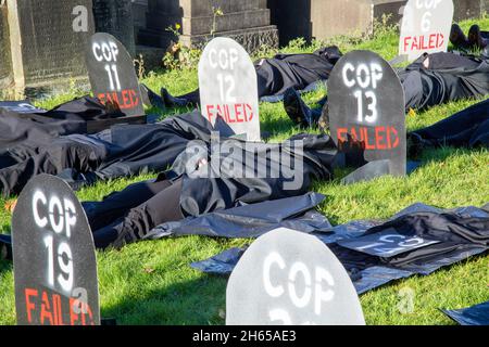 Die Rote Rebellenbrigade schließt sich der Blauen Rebellenbrigade auf dem Friedhof der Glasgow Necropolis zum Begräbnisfeier der COP26 an. Die weinenden Klimaaktivisten empfinden die COP26 als gescheitert und haben eine Scheinbegräbnis für den Gipfel abgehalten. Die COP26 wird zusammen mit allen vorherigen COP-Gipfeln in einem Grab ruhen. Stockfoto