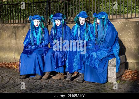 Die Rote Rebellenbrigade schließt sich der Blauen Rebellenbrigade auf dem Friedhof der Glasgow Necropolis zum Begräbnisfeier der COP26 an. Die weinenden Klimaaktivisten empfinden die COP26 als gescheitert und haben eine Scheinbegräbnis für den Gipfel abgehalten. Die COP26 wird zusammen mit allen vorherigen COP-Gipfeln in einem Grab ruhen. Stockfoto