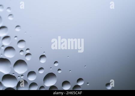 Wassertropfen auf weißem Hintergrund Textur. Hintergrund Glas mit Wassertropfen bedeckt. Blasen im Wasser. Zellen, Wassertropfen auf Glas, Nahaufnahme Makro Stockfoto