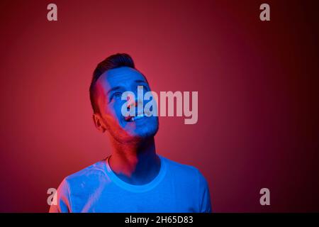 Porträt beleuchtet von Neonlicht. Erfolgreicher und entschlossener junger Mann. Stockfoto