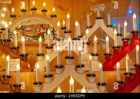 Verkaufsstände des Weihnachtsmarktes in Straßburg, Frankreich. Harmonische Anordnung von Weihnachtskerzen. Eine festliche Atmosphäre und warme Farben. Stockfoto