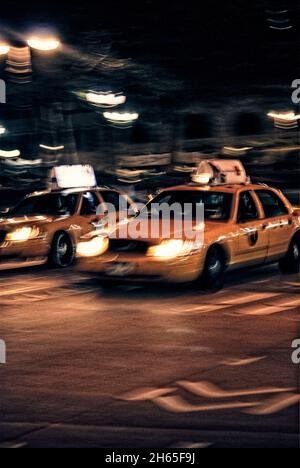 Verschwommenes Bild eines gelben Taxis auf einer Straße in der Nacht in New York Stockfoto