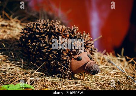 Recycling: Ein Igel und ein Pilz aus Plastikflaschen in einem Garten. Igel aus Zapfen mit eigenen Händen. Stockfoto