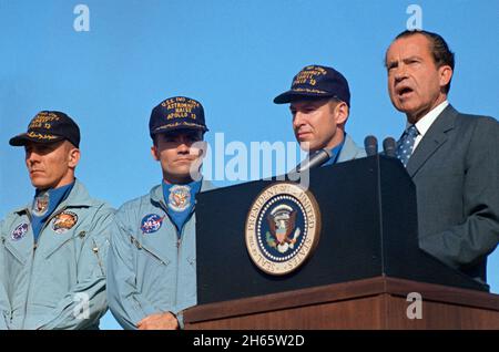 Präsident Richard M. Nixon spricht vor der Hickham Air Force Base, bevor er der Apollo 13-Besatzung die höchste zivile Auszeichnung des Landes überreicht. Die Präsidentenmedaille der Freiheit erhielten die Astronauten James A. Lovell Jr. (neben dem Chief Executive), Commander, John L. Swigert Jr. (links), Kommandomodulpilot, und Fred W. Haise Jr., Mondmodulpilot. Stockfoto