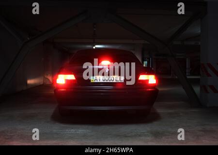 Chernigov, Ukraine - 7. Januar 2014: Tiefgarage. BMW 7 (E38) mit glühenden Lichtern bei schwachem Licht Stockfoto