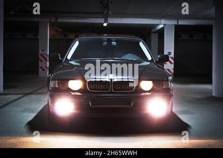 Chernigov, Ukraine - 7. Januar 2014: Tiefgarage. BMW 7 (E38) mit glühenden Lichtern bei schwachem Licht Stockfoto