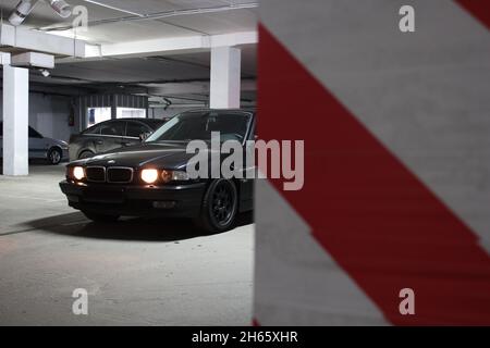 Chernigov, Ukraine - 7. Januar 2014: Tiefgarage. BMW 7 (E38) mit glühenden Lichtern bei schwachem Licht Stockfoto