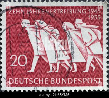 DEUTSCHLAND - UM 1954: Eine in Deutschland gedruckte Briefmarke, die ein Bild zeigt, auf dem Menschen unterwegs waren, die 10 Jahre Vertreibung darstellen (1945 bis 1954) Stockfoto