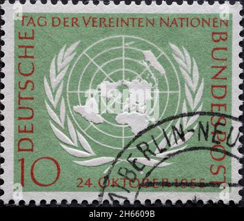 DEUTSCHLAND - UM 1955: Diese Briefmarke zeigt das Symbol der Vereinten Nationen auf einem hellgrünen Hintergrund und wurde am 24. Oktober 1955 veröffentlicht Stockfoto
