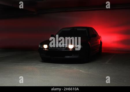 Chernigov, Ukraine - 7. Januar 2014: Tiefgarage. BMW 7 (E38) mit glühenden Lichtern bei schwachem Licht Stockfoto