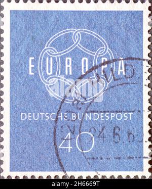 DEUTSCHLAND - UM 1959: Eine in Deutschland gedruckte Briefmarke, die ein weißes Kettensymbol mit dem Wort Europa zeigt. Der Hintergrund ist blau Stockfoto