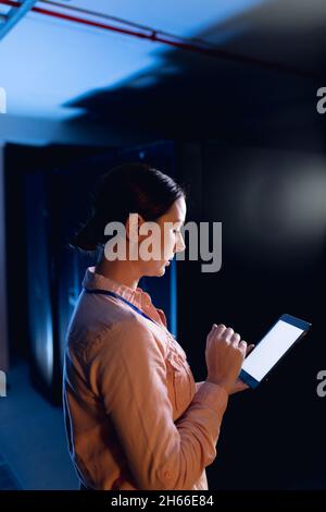 Kaukasische Ingenieurin mit digitalem Tablet im Computerserverraum Stockfoto
