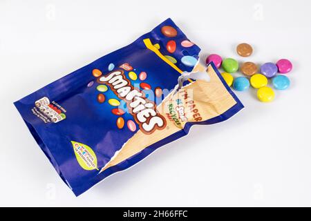 Eine geöffnete recycelbare Papiertüte mit schokoladenüberzogenen Süßigkeiten von Smarties, hergestellt von Nestlé. Stockfoto