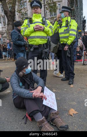 London, Großbritannien. 13. Nov 2021.Extinction Rebellion ergreift Maßnahmen in London, da die COP26 keine Maßnahmen zur Verhinderung der Klimakatastrophe ergriffen hat. Als der Oberbürgermeister in die Stadt zurückkehrte, standen sie auf der Straße und protestierten, einige setzten sich, um sie zu blockieren. Sie weisen auf die Schuld der City of London hin, die Ausbeutung und schmutzige Brennstoffe zu finanzieren, die zu dem Problem geführt haben. Die Polizei zwang sie zum Straßenrand, wo sie während der Prozession weiter protestierten. Peter Marshall/Alamy Live News Stockfoto