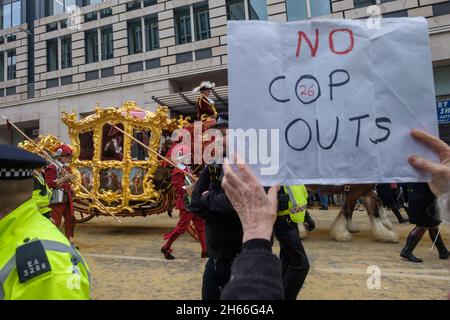 London, Großbritannien. 13. Nov 2021.der Oberbürgermeister winkt von seinem Trainer, als die Aussterbungsrebellion in London Maßnahmen ergreift, da die COP26 keine Maßnahmen ergreift, die zur Verhinderung der Klimakatastrophe erforderlich sind. Sie protestieren friedlich vor der Lord Mayor's Show und weisen auf die Schuld der City of London hin, die Ausbeutung und schmutzige Brennstoffe zu finanzieren, die zu dem Problem geführt haben, Marschieren Sie an den Menschenmassen entlang der Fleet Street vorbei, die für Klimagerechtigkeit aufrufen, während die offizielle Prozession in die entgegengesetzte Richtung vorüber ging. Peter Marshall/Alamy Live News Stockfoto