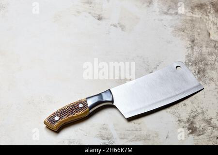 Fleischspalter auf Holzhintergrund. Küchenmesser oder Metzgerspalter aus Edelstahl auf einer Holzplatte Stockfoto