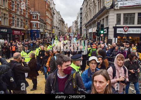 London, Großbritannien. November 2021. Demonstranten marschieren während des Protests.Aussterbungsrebellion Demonstranten marschierten durch die Stadt und störten die Show des Oberbürgermeisters aus Protest gegen das "Scheitern" der Klimakonferenz COP26. Die Lord Mayor's Show ist eine öffentliche Parade anlässlich der Einweihung des neuen Lord Mayor der City of London, dem Finanzdistrikt der Hauptstadt. Kredit: SOPA Images Limited/Alamy Live Nachrichten Stockfoto