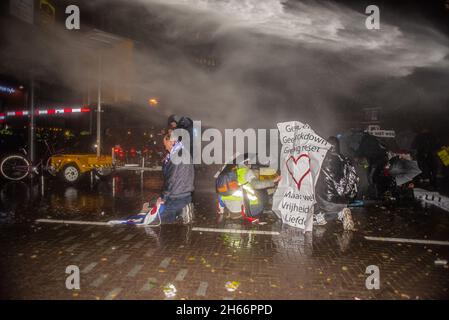 Den Haag, Niederlande. November 2021. Polizeibeamte verwendeten Wasserwerfer, um Demonstranten während der Demonstration zu zerstreuen.Polizeibeamte von Riot sehen sich Demonstranten gegenüber, als sie sich während einer Pressekonferenz des niederländischen Premierministers Mark Rutte in Den Haag versammelten, um neue Covid-19-Beschränkungen bekannt zu geben. (Foto von Charles M Vella/SOPA Images/Sipa USA) Quelle: SIPA USA/Alamy Live News Stockfoto