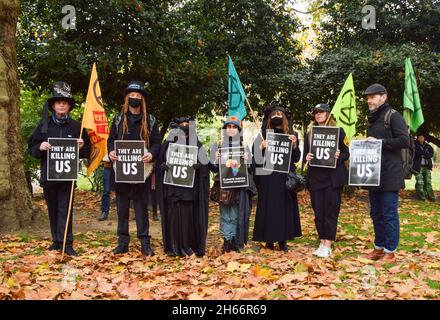 London, Großbritannien. November 2021. Demonstranten halten während des Protestes Plakate mit dem Titel "Sie töten uns" auf den Lincoln's Inn Fields.Extinction Rebellion Demonstranten marschierten durch die Stadt und durchlösten die Lord Mayor's Show aus Protest gegen das "Scheitern" der COP26-Klimakonferenz. Die Lord Mayor's Show ist eine öffentliche Parade anlässlich der Einweihung des neuen Lord Mayor der City of London, dem Finanzdistrikt der Hauptstadt. (Foto: Vuk Valcic/SOPA Images/Sipa USA) Quelle: SIPA USA/Alamy Live News Stockfoto