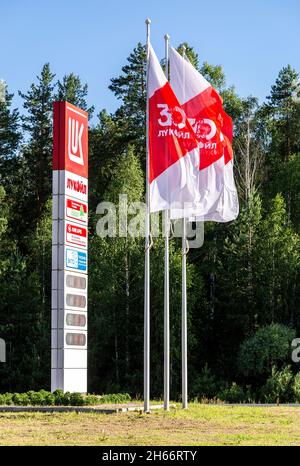 Mordovia, Russland - 5. Juli 2021: Führungsschild und Flaggen der Lukoil-Tankstelle. Lukoil-Tankstelle. Lukoil ist eine der größten russischen Ölgesellschaften Stockfoto