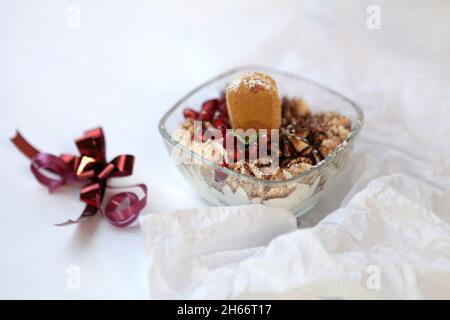 Tiramisu-Keks aus Glas auf weißem Tisch. Traditionelles italienisches Dessert mit Schokoladensauce Stockfoto