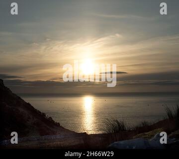 Ein Blick auf den Nordatlantik schoss, als die Wintersonne über der irischen Küste aufgeht. Stockfoto