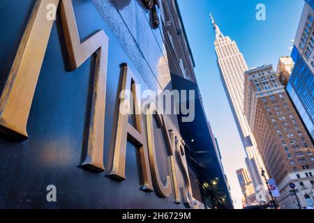 Macy's Kaufhaus Schild an der Eight Avenue und West 34th Street mit dem Empire State Building im Hintergrund, 2021, NYC, USA Stockfoto